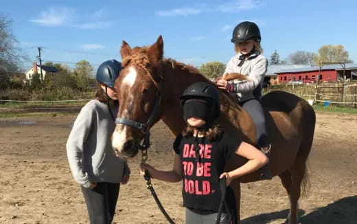 a person and a girl riding a horse