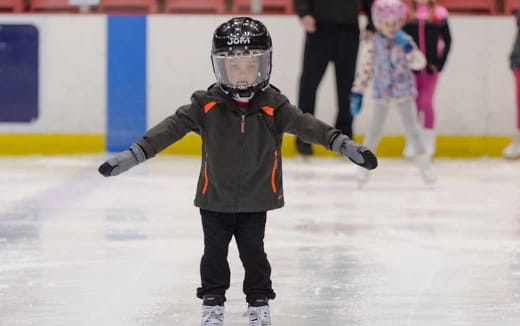 a boy wearing a helmet and ice skates