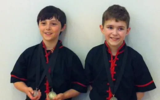 a couple of boys wearing medals