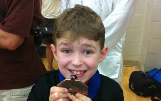 a boy holding a chocolate cupcake