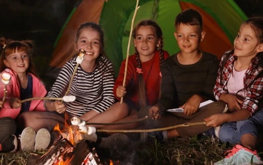 a group of children sitting around a fire