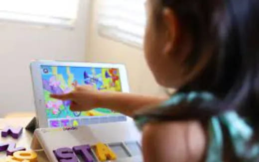 a child drawing on a tablet