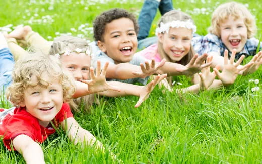 a group of children lying in the grass