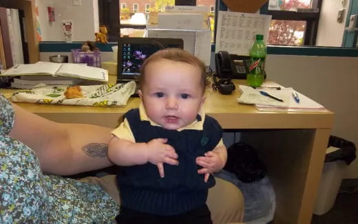 a baby sitting at a desk