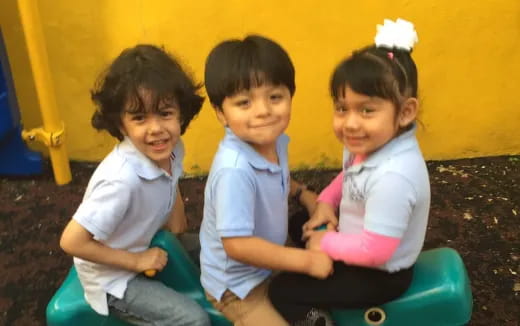 a group of children sitting on a toy train