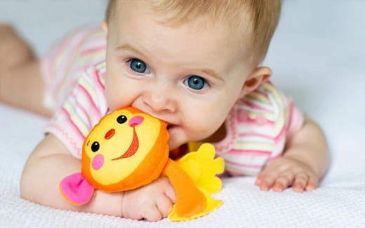 a baby holding a yellow toy