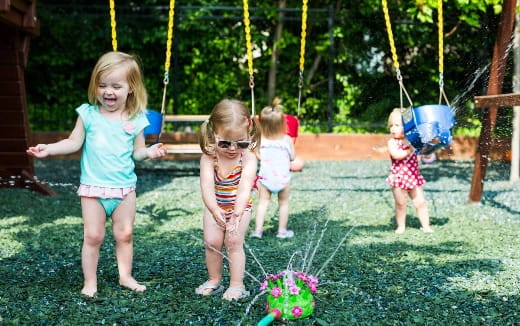 a group of children playing on a swing set