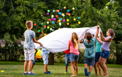 a group of kids playing with a white tent