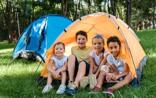 a group of people sitting in front of a tent