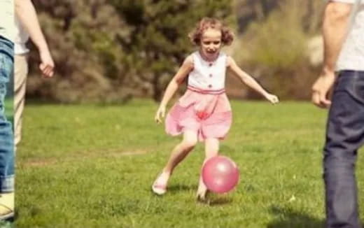 a little girl playing with a ball