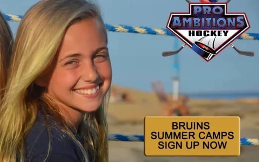 a woman smiling with a sign in the background