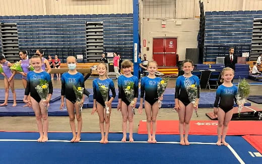 a group of girls in leotards on a track