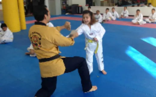 a man and a woman in karate uniforms on a blue mat