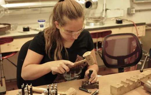 a woman working on a piece of wood