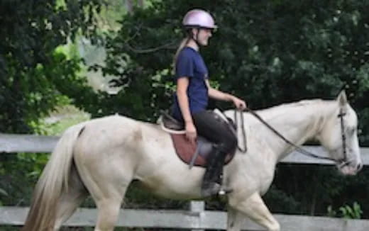 a girl riding a white horse