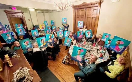 a group of people sitting around a table with art on it