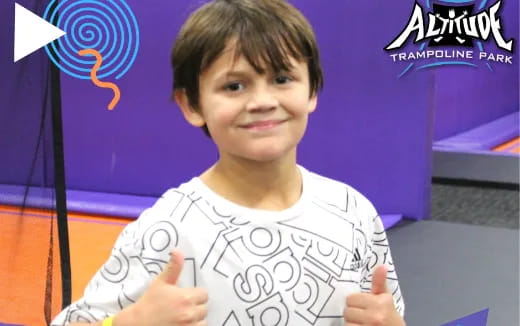 a boy smiling and pointing
