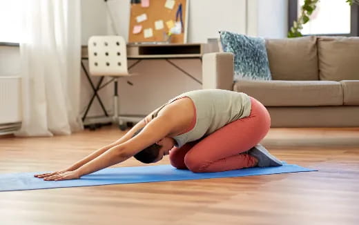 a person doing yoga on a yoga mat in a living room