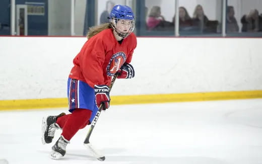 a person wearing a hockey uniform and helmet on ice