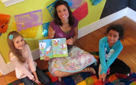 a group of children sitting on the floor holding a box