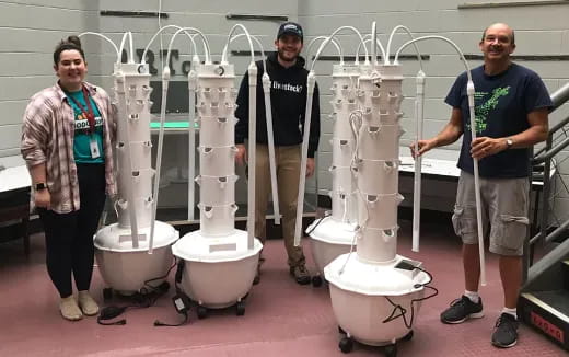 men standing next to a row of toilets