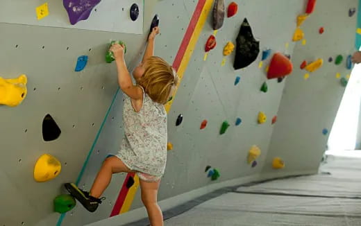 a girl climbing a wall