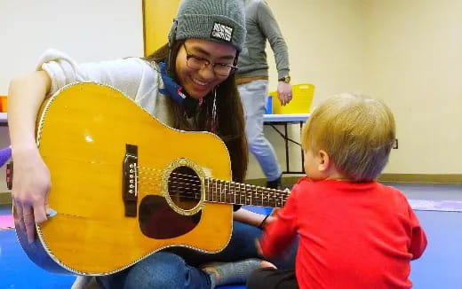 a person playing a guitar with a boy