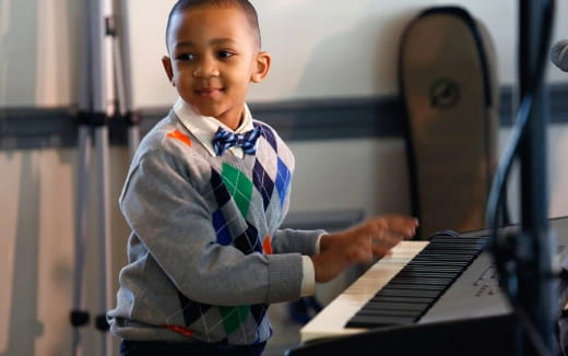 a young boy playing a piano