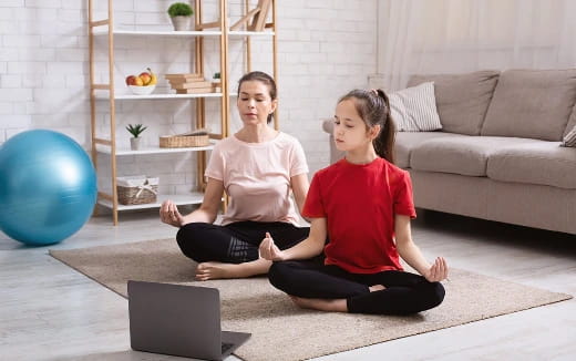 a person and a girl sitting on the floor with a laptop