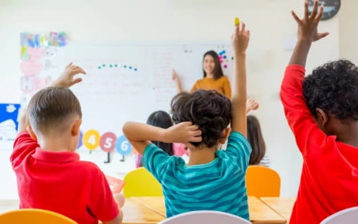 a group of children raising their hands