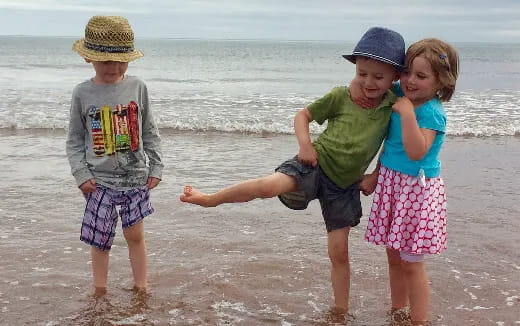 a group of children playing on a beach