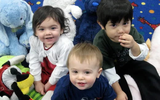 a group of children sitting on a bed