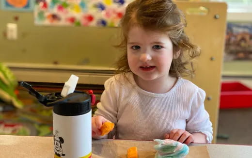 a little girl sitting at a table