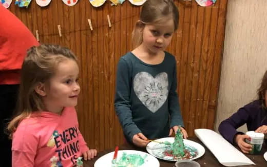 a group of children sitting at a table eating food