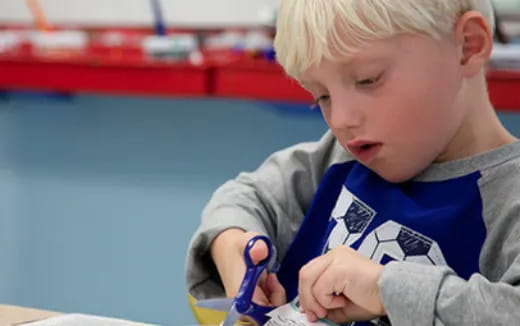 a young boy is holding a pair of scissors