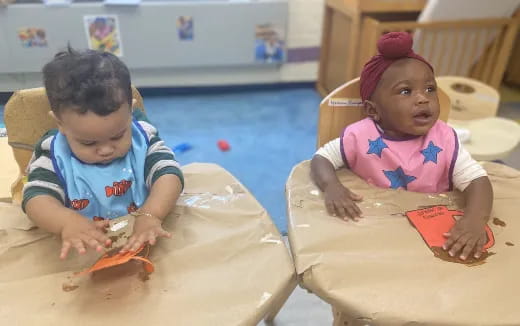 a couple of young children playing with toys on a table