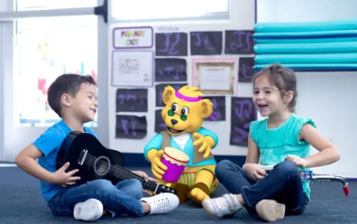 a person and a girl playing a guitar and a stuffed animal