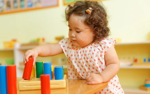 a little girl playing with colorful blocks