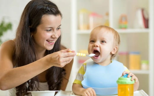 a person feeding a baby