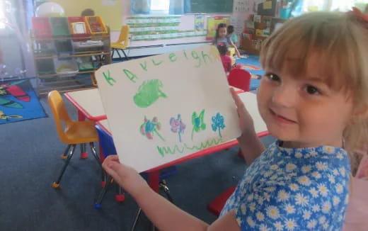 a child holding a drawing