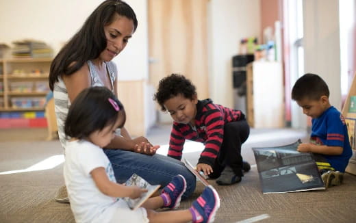 a person and kids looking at a tablet