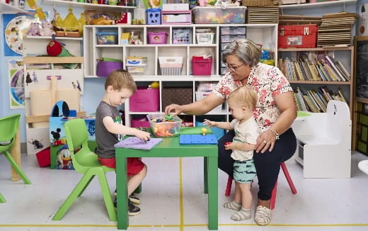 a person and two children sitting at a table