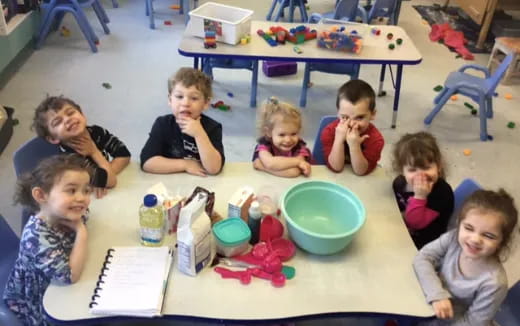 a group of children sitting around a table