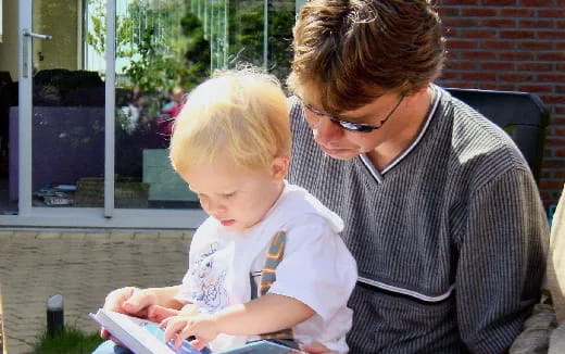 a person reading a book to a child