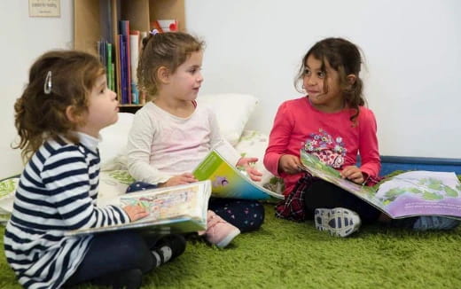 a group of children sitting on the floor reading books