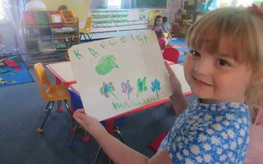 a child holding a drawing