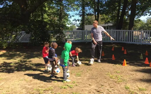 a man and kids playing with a football ball