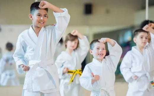 a group of children in white karate uniforms