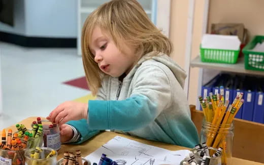 a young girl sitting at a desk