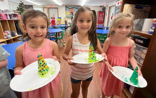 a group of girls holding plates of cake